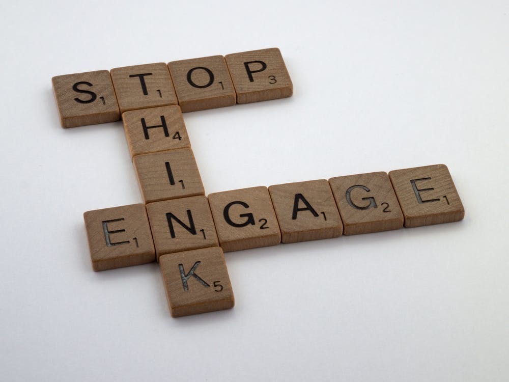 wooden blocks in a crossword puzzle pattern that spell the words "stop, think, engage"